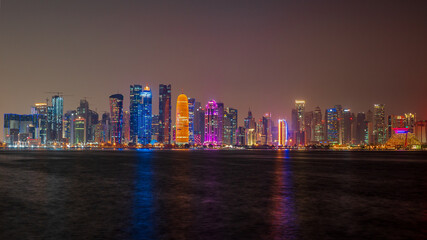 view of doha corniche during night along with fanar building.