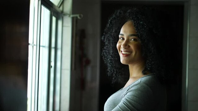 A young Brazilian woman turning head to camera smiling a diverse person portrait