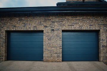 Garage Door. A double garage with blue doors at the end of a driveway