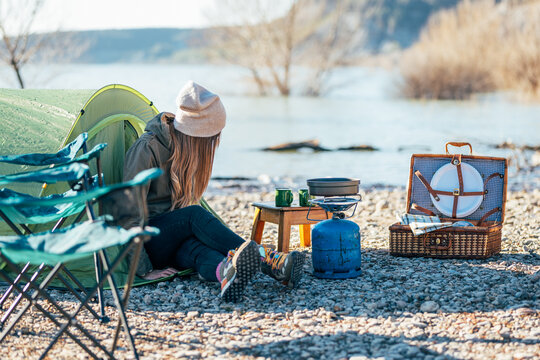 Traveling woman sitting in tent at campsite