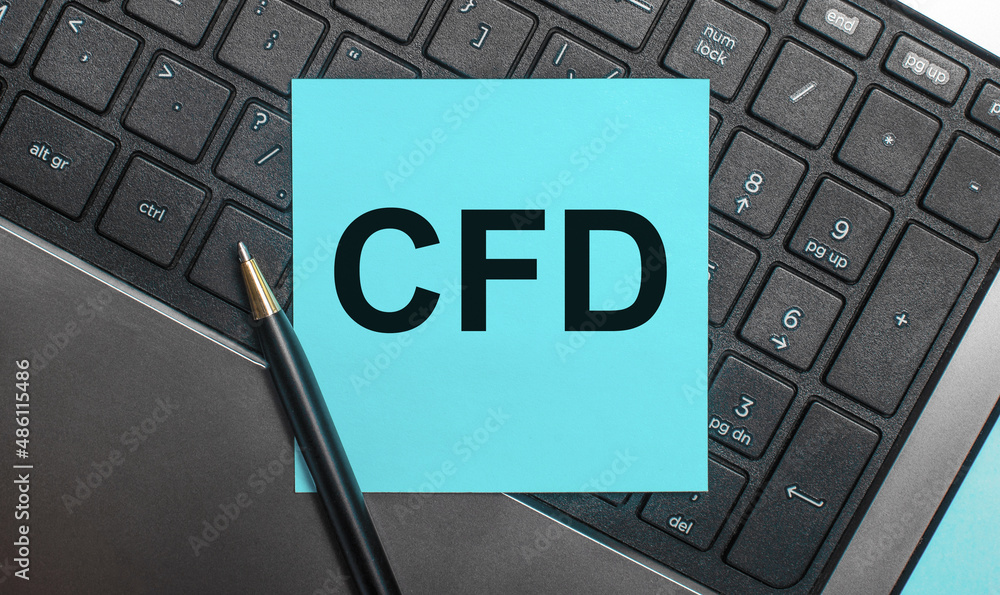 Aufkleber the computer keyboard has a pen and a blue sticker with the text cfd contract for difference. flat l