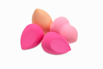 Four make-up sponges of different shapes on a white background