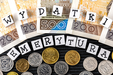 The wording "wydatki emerytury" translated as "expenses pensions" and many Polish coins and banknotes on the black background. New taxation rules in Poland. Pension versus expenses. 