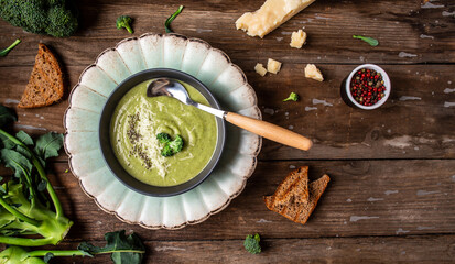broccoli soup puree with parmesan and crispy croutons on a dark wood background. Vegan soup puree of green vegetables. Vegetarian and diet food. place for text, top view