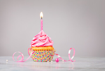 Pink Birthday Cupcake with Candle over Grey Background - 486116441
