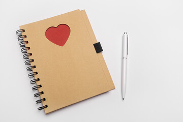 Top view of open spiral blank notebook with pen on white desk background with stars. Isolated on gray backdrop.