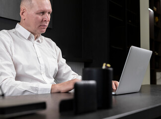 Business man working at laptop computer at office desk.