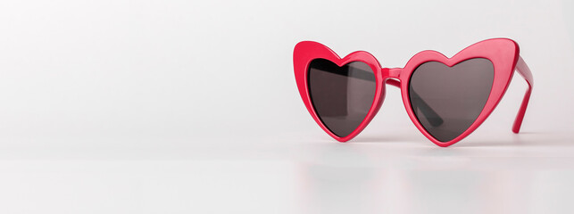 Banner with heart-shaped sun glasses. Valentines red sunglasses on background with copy space. High...