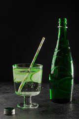 Detox water refreshing with cucumber and mineral water in a glass on a dark background. Drink for dietary healthy nutrition and weight loss.