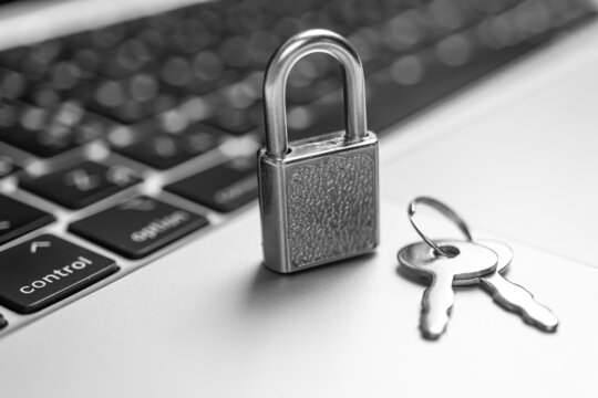 Computer security concept. Padlock with keys on computer keyboard, laptop in office. Cyber security and privacy background photo