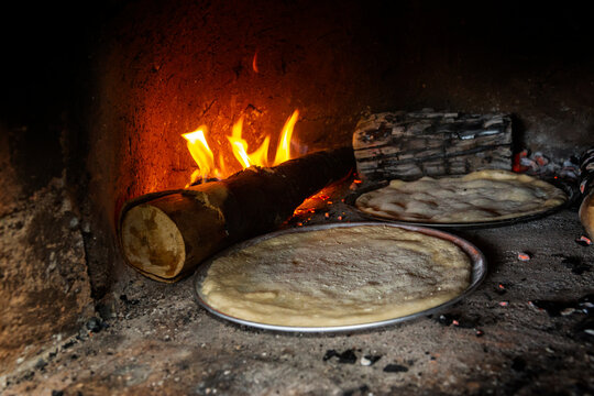 Cooking a pizza in a wood oven