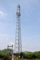 Telecommunication towers with TV antennas and satellite dish on clear blue sky