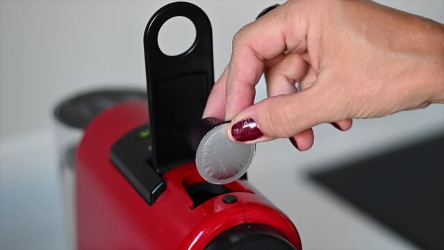 woman's hand placing coffee capsule in the express machine