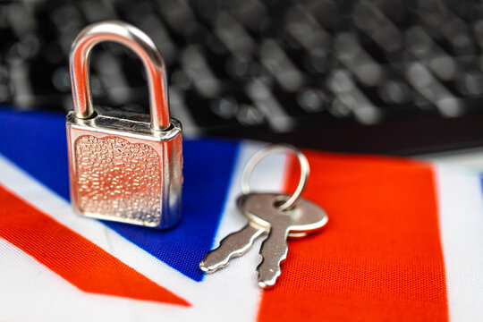 United Kingdom cyber security concept. Padlock on computer keyboard and UK flag. Close-up view photo