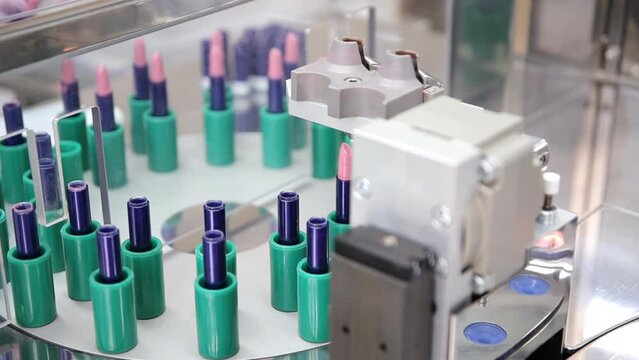 The process of lipstick production in a cosmetics factory. Cosmetic machine.