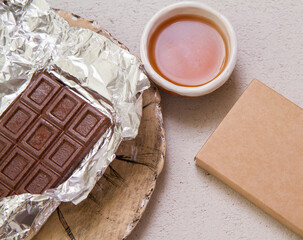 open veggie chocolate bar on foil next to tea and plate