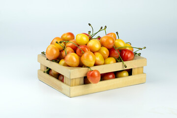 Cherries in box. Sweet yellow rainier cherry in wooden box on white background.