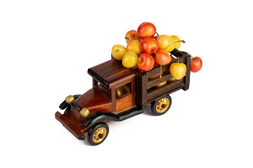 Ripe sweet rainier cherries in a wooden toy truck on white background