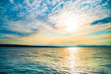 Obraz na płótnie Canvas the sun rises over the blue sea on a warm summer day.