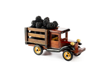 Blackberry in wooden toy truck on white background.