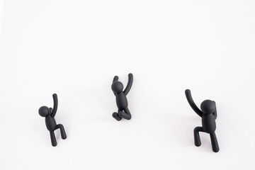 3 black 3D puppets climbing over a white background, human character , person hanging from a white wall, concept of self improvement and help each other