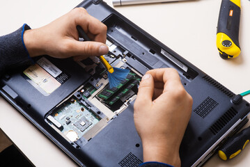 Wizard repairs laptop with tools and hands