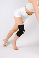 Knee Support Brace on leg isolated on white background. Elastic orthopedic orthosis. Anatomic...