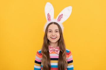 happy easter child in bunny ears and bow tie on yellow background