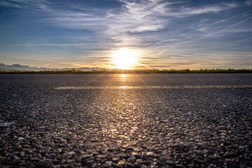 Asphalt road in sunset close up, landscape with mountains in sunset