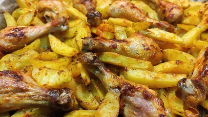 Fried potatoes with chicken legs close-up. Food background.