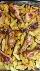 Fried potatoes with chicken legs close-up. Food background.