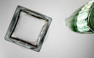 Bottle with drink and ice on table from below 