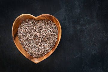 Heart-shaped bowl with raw and dried lentils