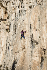 Beautiful Woman Climbing on the High Rock . Adventure and Extreme Sport Concept
