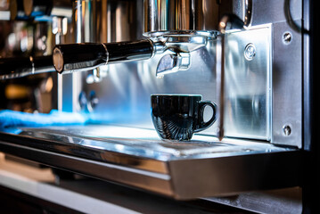 Cup of coffee in the coffee machine ready to start the breakfast service in a restaurant. Waiters