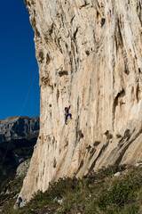 Beautiful Woman Climbing on the High Rock . Adventure and Extreme Sport Concept
