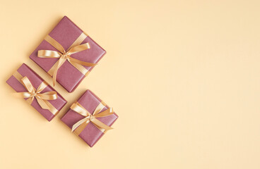 Pink gift boxes on yellow background with golden bow . Greeting card. Christmas, woman, mother day...