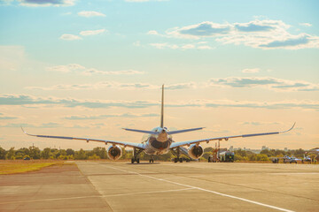 Rear view of an airplane being refueled from a tanker on a sunny day and a beautiful sky.
