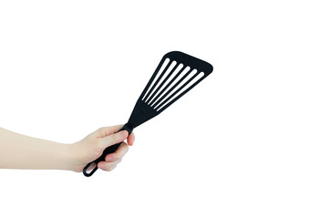 Kitchenware. Black plastic spatula for frying in the hand of caucasian woman.