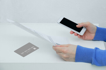 Smartphone in the hand of a caucasian woman and paper document. Concept.