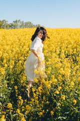 Fototapeta premium woman standing in rapeseed field