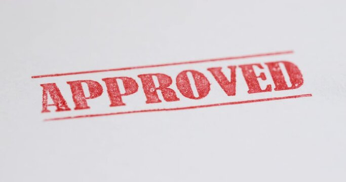 A stamp Approved is placed on a sheet of white paper, copyspace compocition. 4k video