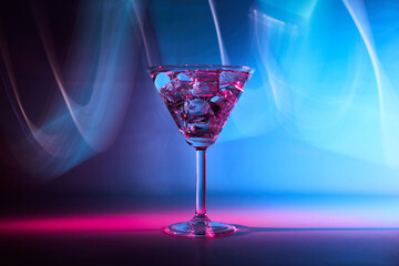 Martini cocktail drink in neon iridescent pink and blue colors.