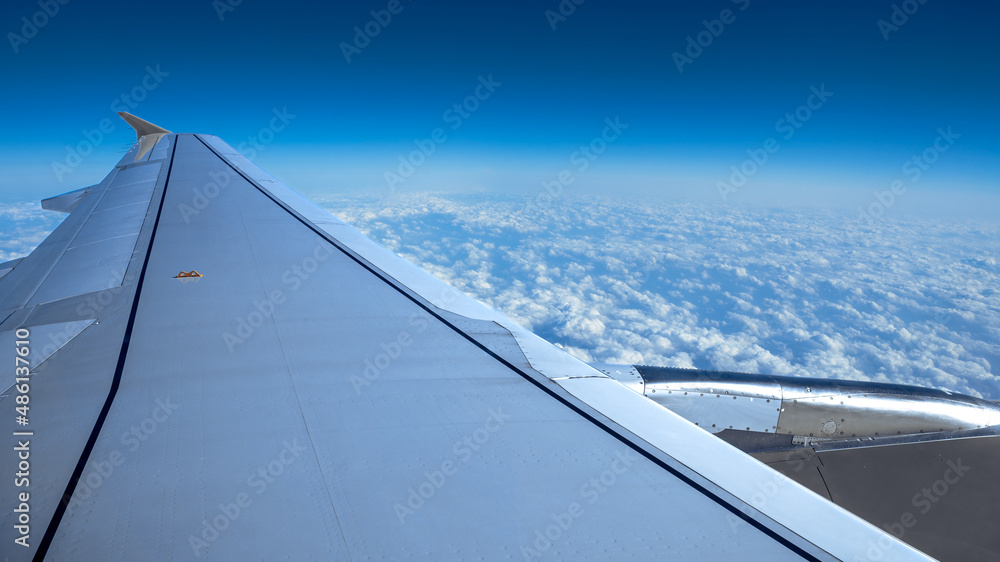 Wall mural traveling by air. turbine and plane wing in flight trip with beautiful sky.