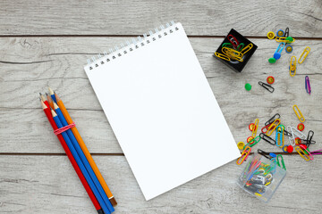Blank paper and colorful pencils on a wooden table. View from above