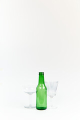 Set of green glass beer bottle and two goblets