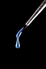 a drop of paint dripping from a brush. nail polish. blue paint