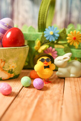 Obraz na płótnie Canvas Easter background. decoration for Easter with colorful eggs and chicken on a wooden table
