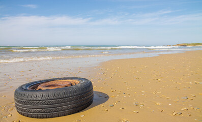 old wheel from the car on the beach
