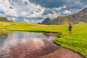 Escena de un montañero observando el paisaje junto a los ibones de Anayet, Huesca